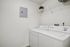 Chic laundry room with modern washer and dryer, featuring a sleek white aesthetic and efficient organization.