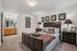 Inviting bedroom featuring a cozy bed with elegant decor, stylish artwork, and a charming vanity area with natural light.