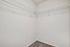 Spacious walk-in closet with sleek double shelves and plush carpet, perfect for organization and style.
