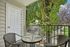 Charming balcony view with cozy seating overlooking lush greenery, perfect for relaxing outdoors.
