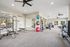 Modern fitness center with state-of-the-art equipment, including weight machines, exercise bikes, and vibrant yoga balls, set in a spacious, bright room with large mirrors.