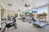 Modern gym with large windows featuring exercise bikes and treadmills, offering a bright and inviting workout space with scenic outdoor views.