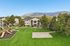 Charming apartment complex with scenic mountain views, lush green lawns, a playground, and basketball court nestled amid mature trees.