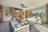Inviting outdoor lounge with modern sofas, brick fireplace, and vibrant garden views, perfect for relaxation and entertaining.