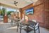 Charming outdoor patio with modern brick accents, ceiling fan, and poolside view, perfect for relaxing and entertaining.