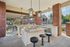 Chic outdoor kitchen with elegant pendant lights, granite countertops, and stylish bar seating, perfect for entertaining.