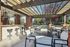 Charming outdoor patio with elegant pergola, stylish bar seating, and lush greenery for a delightful dining experience.