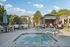 Inviting outdoor hot tub area with stylish seating, set in a tranquil apartment complex with lush greenery.