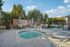 Inviting outdoor space featuring a relaxing hot tub surrounded by comfortable seating and lush greenery, perfect for leisure and social gatherings.