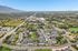 Breathtaking aerial view of a vibrant residential community surrounded by lush greenery and mountain vistas, perfect for tranquil living.