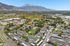 Scenic aerial view showcasing a picturesque apartment complex surrounded by lush greenery and vibrant autumn foliage, with majestic mountain backdrop.
