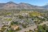 Stunning aerial view of a picturesque suburban neighborhood nestled against majestic mountains, showcasing lush greenery and well-planned residential areas.