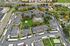 Aerial view of a vibrant apartment complex with landscaped gardens, central pool area, and ample parking, showcasing a serene and inviting community atmosphere.