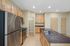 Modern kitchen with sleek stainless steel appliances, granite countertops, and abundant wooden cabinetry.