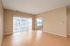 Bright and spacious living area with beautiful wood floors and large windows, showcasing a modern design and abundant natural light.