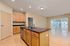 Modern open-concept kitchen and living area featuring elegant wooden cabinetry, a sleek kitchen island, and large sliding doors offering ample natural light.