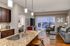 Elegant open-concept apartment featuring a modern kitchen with granite countertops, cozy living room, and a stunning view through large sliding glass doors.