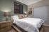 Cozy bedroom with rustic wood furniture, elegant decor, and soft lighting, perfect for restful nights.
