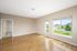 Bright, airy room with elegant hardwood floors and large windows offering scenic views, perfect for a cozy living space.