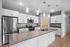Modern kitchen with sleek granite countertops, stainless steel appliances, and elegant pendant lighting under a bright ceiling.
