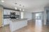 Modern apartment with sleek open-concept kitchen, featuring stainless steel appliances, large island, and bright living space.
