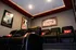Chic home theater room featuring plush black leather recliners, ambient lighting, and classic movie posters for a cinematic experience.