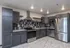 Modern kitchen with sleek dark cabinetry, stainless steel appliances, and stylish backsplash, perfect for culinary enthusiasts.
