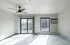 Modern apartment interior with a ceiling fan, large windows offering plenty of natural light, and sleek, stylish flooring, perfect for urban living.