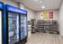 Modern micro-market featuring a well-stocked beverage fridge with Pepsi products and a variety of snacks on sleek shelves, offering a convenient grab-and-go shopping experience.