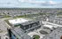 Aerial view of a vibrant residential community featuring modern apartment buildings, expansive green spaces, and well-planned roadways, offering a perfect blend of urban convenience and suburban tranquility.