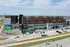 Modern apartment complex featuring elegant multi-story architecture with commercial spaces and ample parking, set against a picturesque skyline.