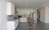 Modern kitchen with sleek white cabinetry, stainless steel appliances, and stylish wood-accented island, perfect for culinary creations.