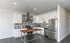 Modern kitchen with sleek stainless steel appliances, stylish backsplash, and ample white cabinetry, ideal for culinary enthusiasts.