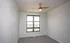 Bright and inviting bedroom with large window, fresh white walls, and a modern ceiling fan.