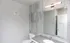 Modern bathroom with sleek gray tiles, elegant vanity, and large mirror.
