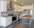 Modern kitchen with sleek stainless steel appliances, stylish tile backsplash, and elegant cabinetry featuring a wooden island.