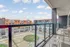 Modern balcony view overlooking a vibrant courtyard with contemporary buildings and lively atmosphere, perfect for urban living.