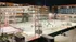 Vibrant nighttime scene of an outdoor ice skating rink surrounded by modern apartments, with people enjoying skating under festive lights.