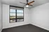 Bright and airy room with a modern ceiling fan, large windows offering scenic views, and fresh carpet flooring.