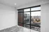 Bright, modern apartment window with a stunning cityscape view, featuring sleek flooring and stylish design.