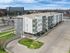 Contemporary apartment building with modern design, ample parking, and lush green surroundings in a vibrant urban setting.
