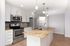 Modern kitchen with granite countertops, stainless steel appliances, and pendant lighting, perfect for culinary adventures.