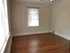Bright, airy room with elegant hardwood floors and a classic ceiling fan, perfect for a cozy living space.