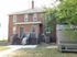 Charming brick duplex with inviting front porches and lush greenery, perfect for family living and entertaining.