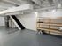 Bright and spacious basement with modern utility setup and ample wooden storage shelves, offering functionality and design potential.