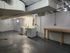 Spacious basement laundry area with modern appliances and a convenient utility table, perfect for efficient home living.