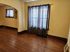 Charming living area with rich hardwood floors, elegant archway, and large window with soft drapes.