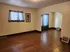 Inviting living space with warm wooden floors, elegant archway, and soft natural light through chic curtains.