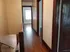 Charming hallway with polished hardwood floors leading to sunlit rooms, perfect for a warm and inviting home.