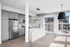 Modern kitchen with sleek gray cabinets, stainless steel appliances, and a bright open layout with large windows.